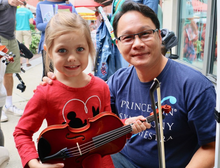 Girl holding violin with PSO musician