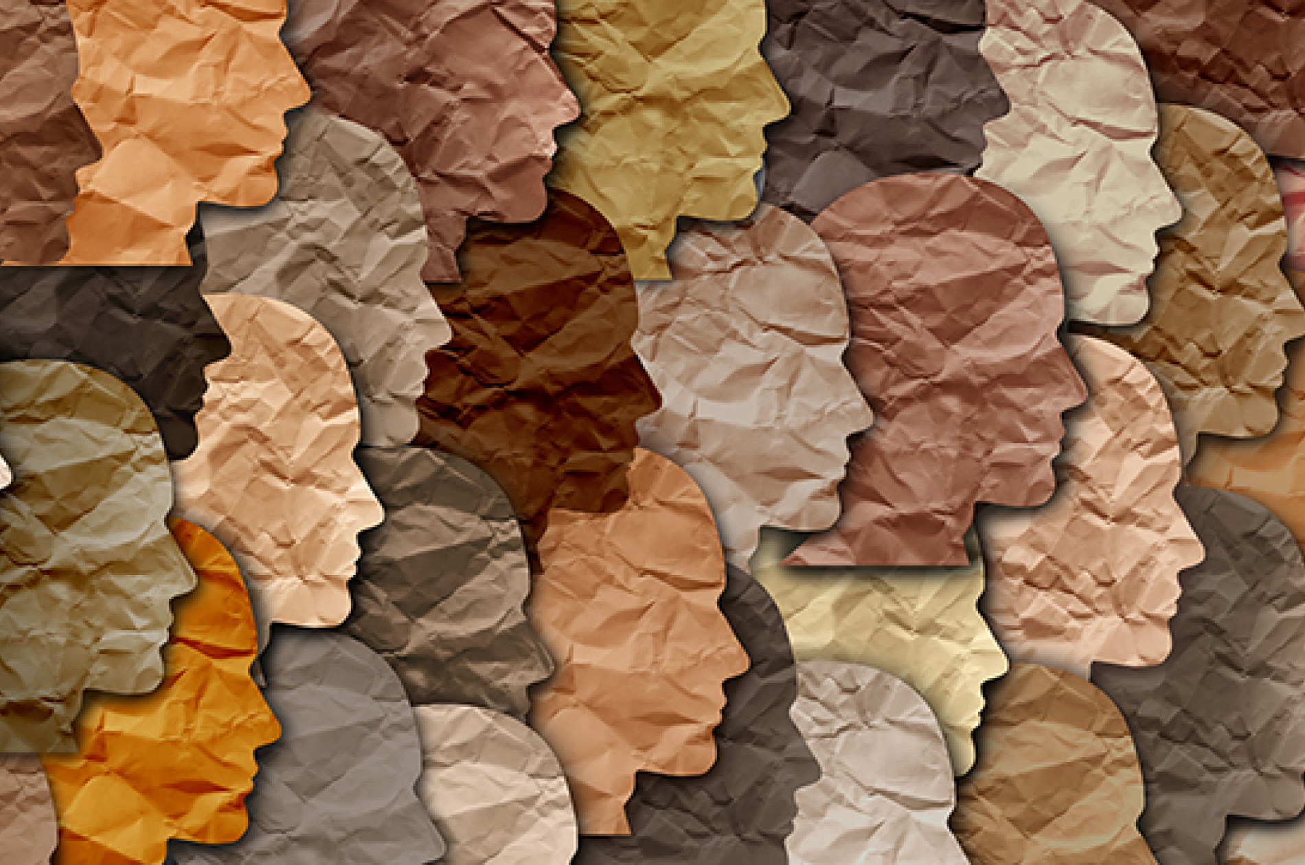 An array of crinkled, cut-out paper faces in profile, with many hues of flesh tone.