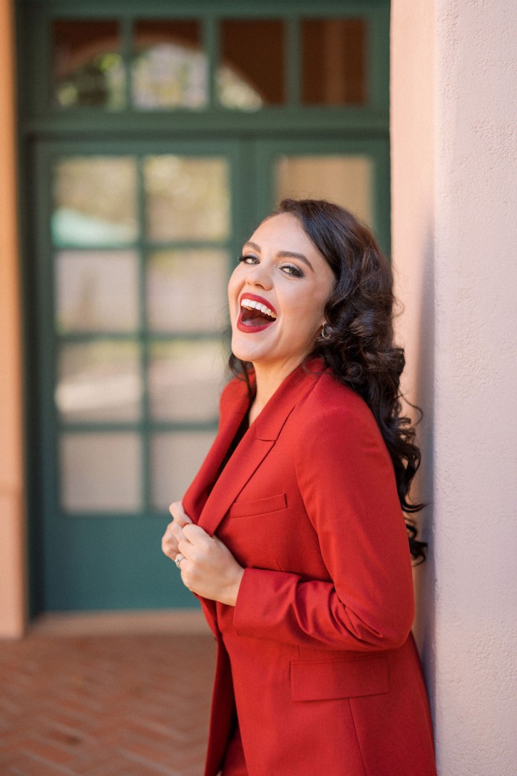 Kelly Guerra, soprano, wearing red suit and matching lipstick