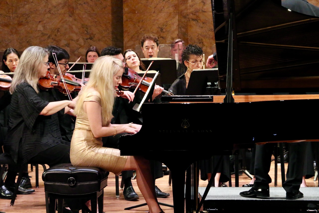 Pianist Natasha Paremski performing with the Princeton Symphony Orchestra, 9 members seen beyond her, onstage in May 2025.