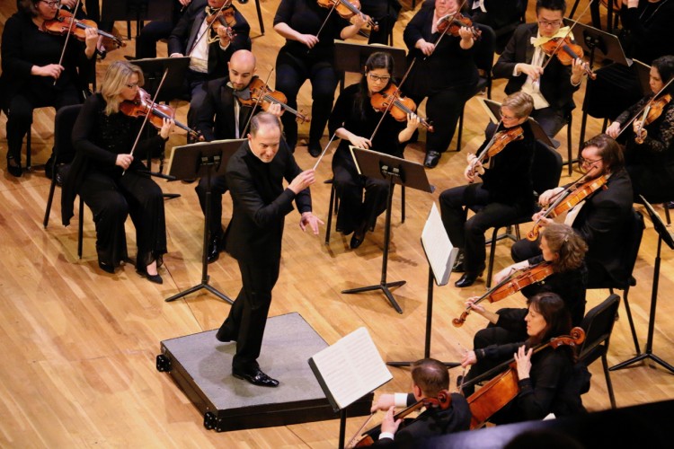Rossen Milanov conducts the PSO in concert; everyone wears concert black.