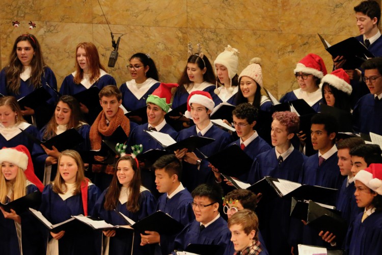 Children singing in a choir with Santa hats