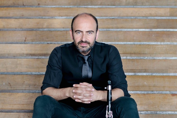 Gentleman sitting on some stairs with his clarinet.