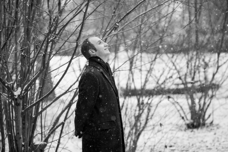 Pianist Alexander Gavrylyuk gazing up while outside in a snow fall