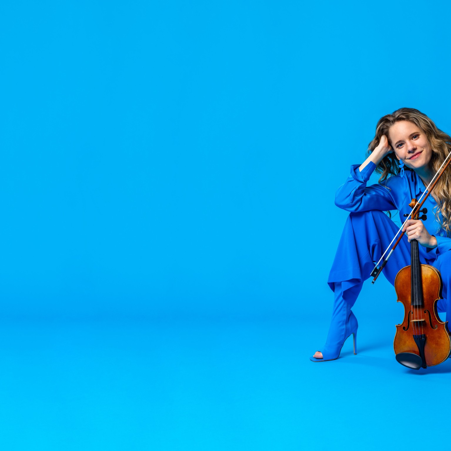 Aubree Oliverson, violin - promotional photo against bright blue field