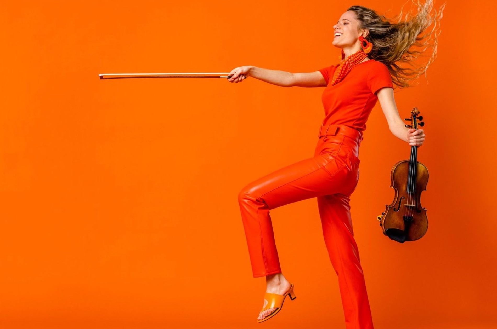 Aubrey Oliverson, violin - monochromatic publicity shot in orange against orange ground