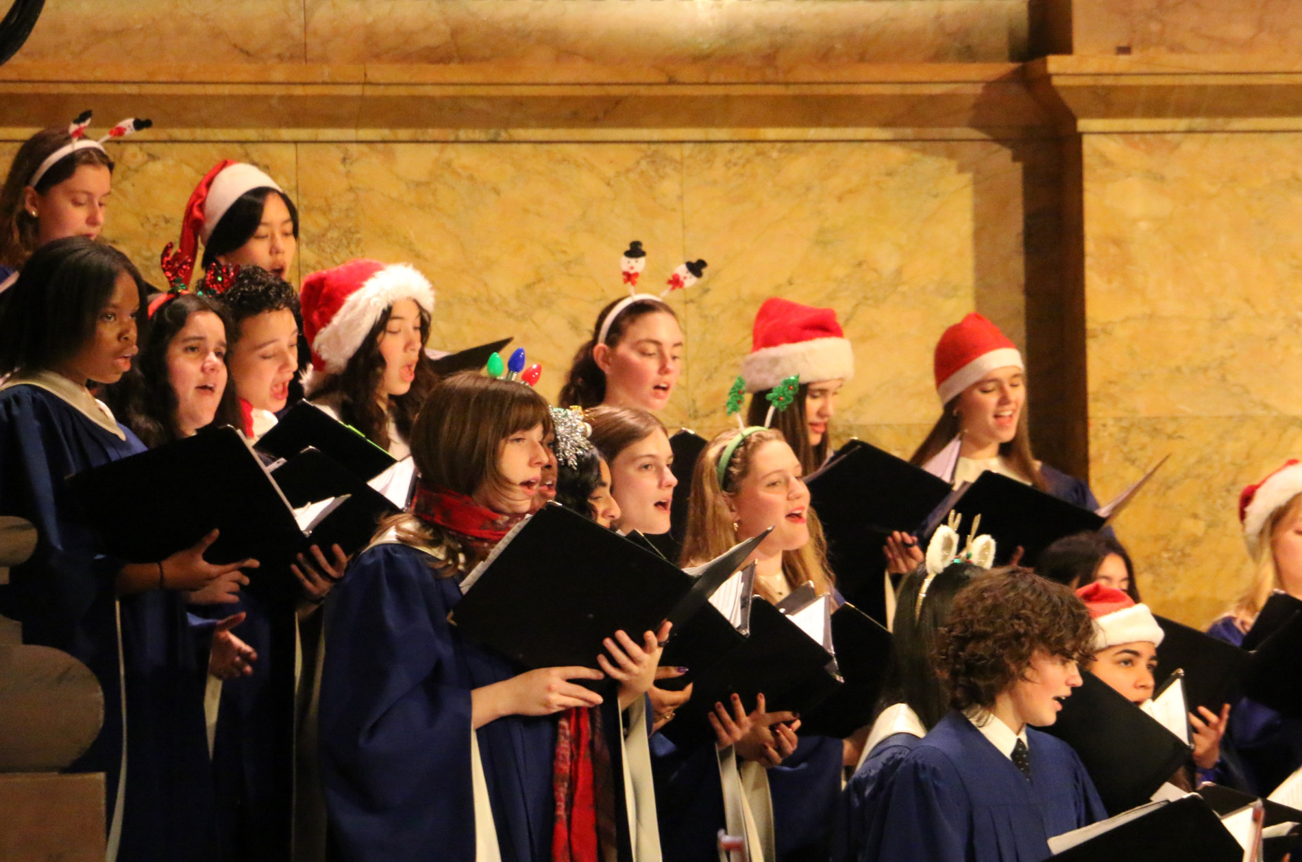 PHS Choir performing at 2025 Holiday POPS! concert wearing holiday hats.